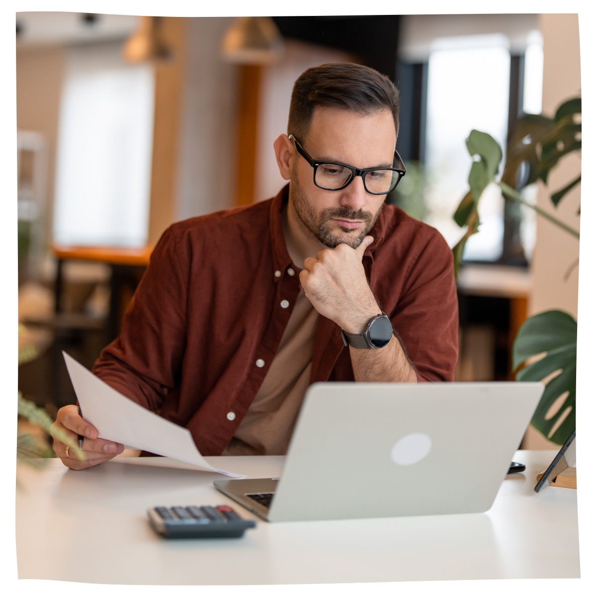 Man using laptop and calculator looking at prices