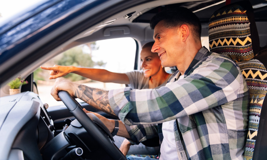 Man and woman driving a car in nature