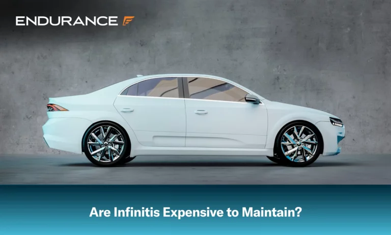 A white Infiniti car in front of a concrete wall