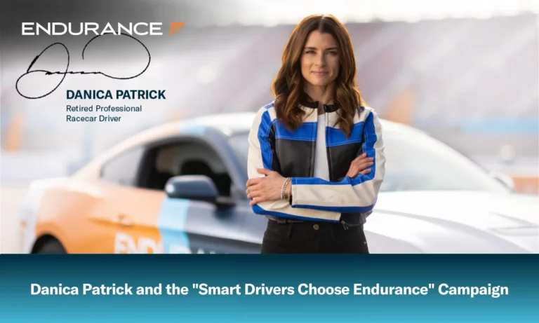 Danica Patrick standing with her arms crossed in front of an Endurance car