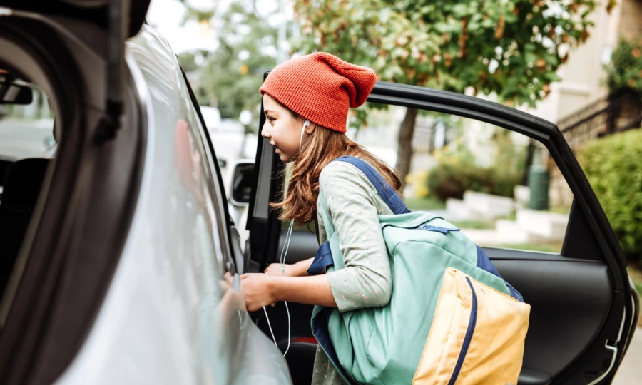 Teen getting into car to go to school