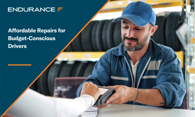 Car mechanic in blue uniform holding a payment terminal for a customer