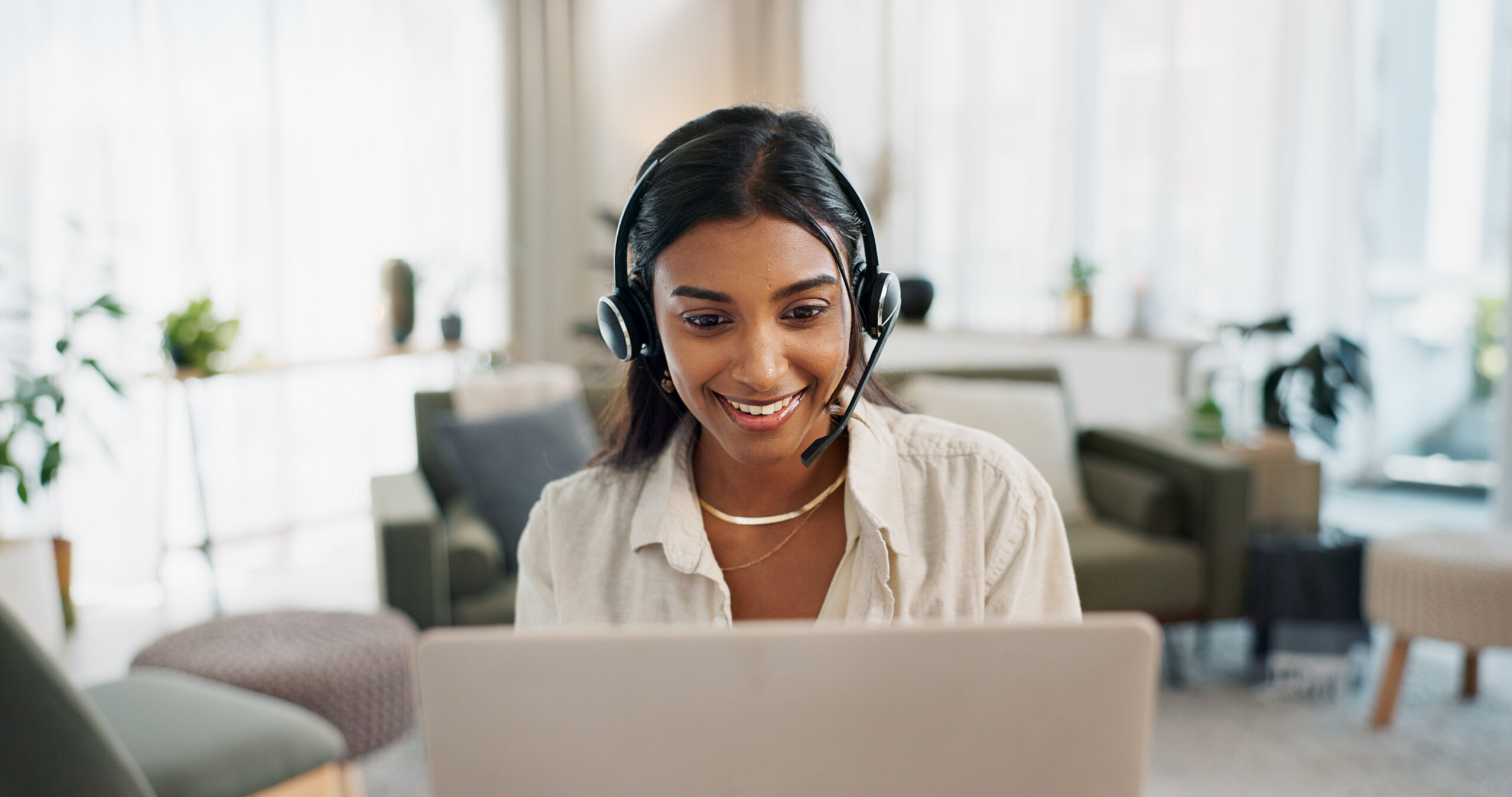 Mujer feliz, centro de llamadas y auriculares en una laptop, en atención al cliente, soporte o telemarketing desde casa. Rostro de una consultora o agente freelance que trabaja a distancia para asesoramiento online.