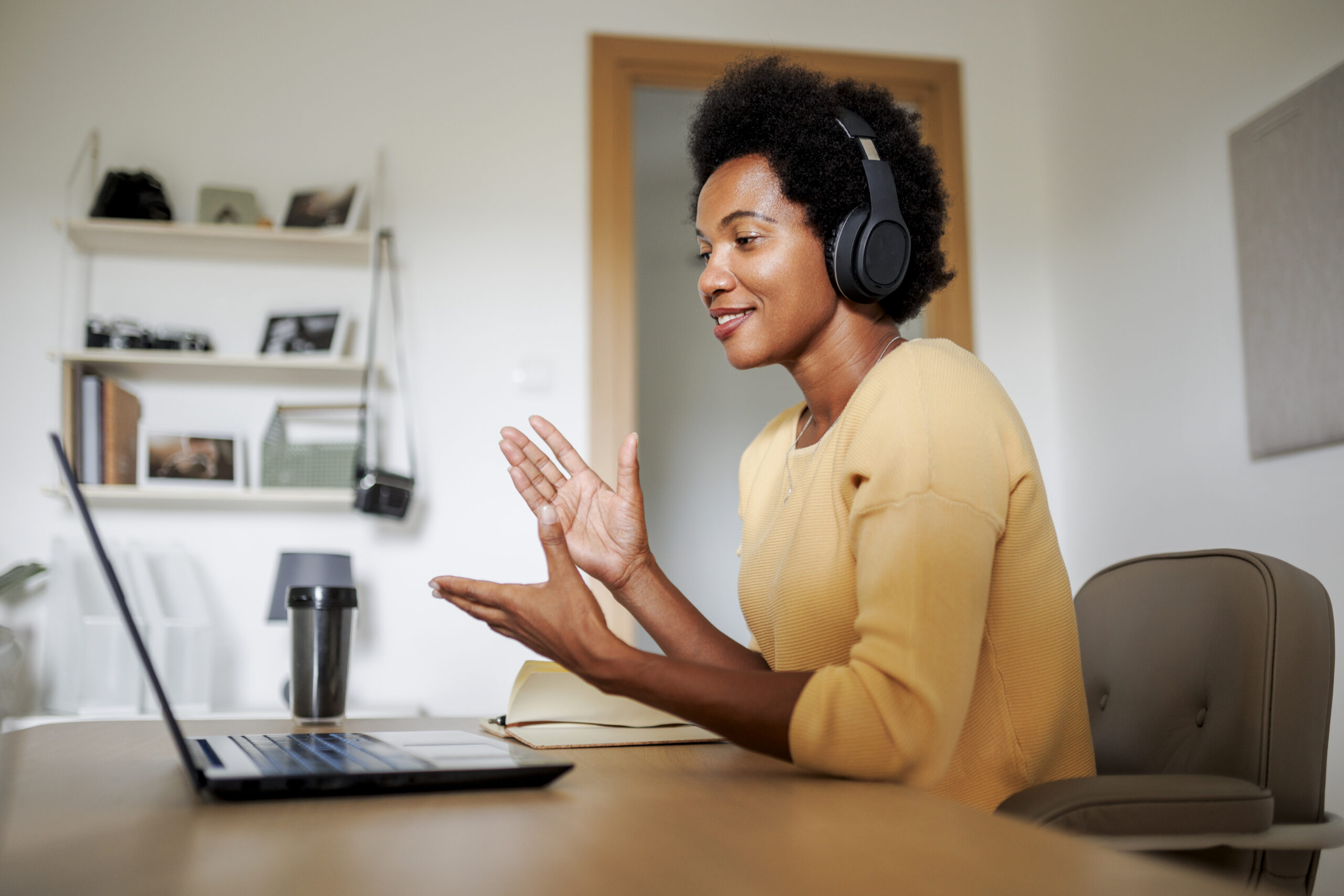Mujer de negocios con auriculares haciendo una videollamada en la oficina