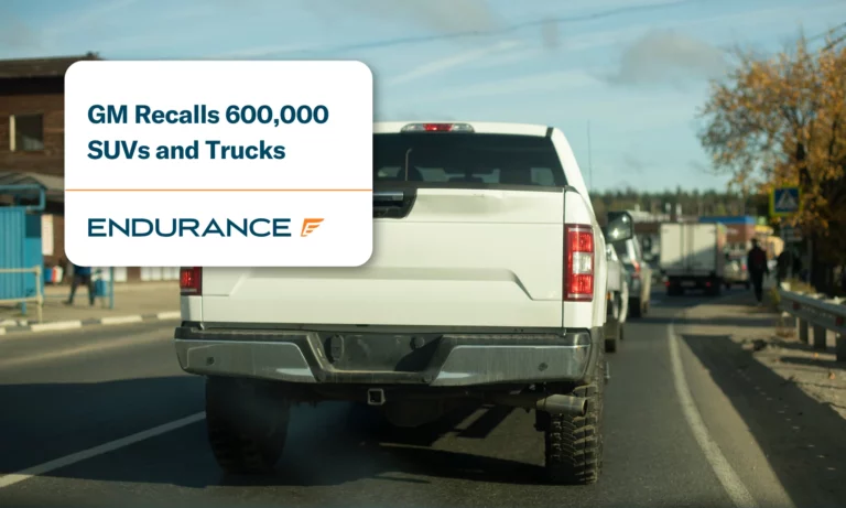 White pickup truck rides down a road