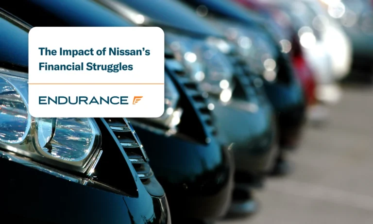 A line of Nissan cars in a factory parking lot