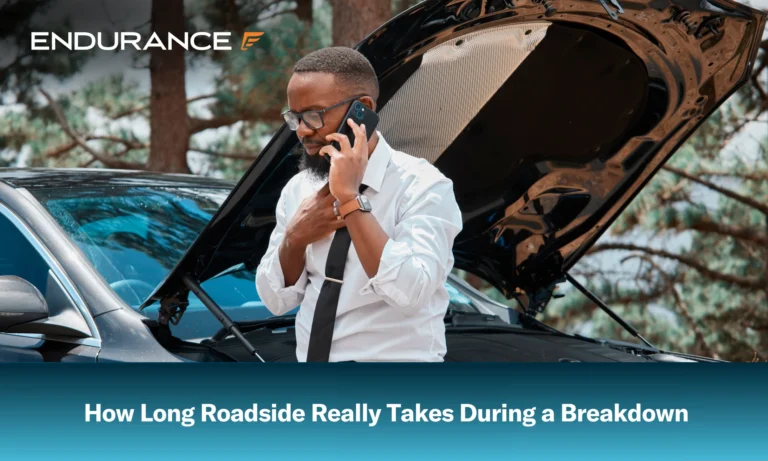 An African American man on his phone beside his car with an open hood