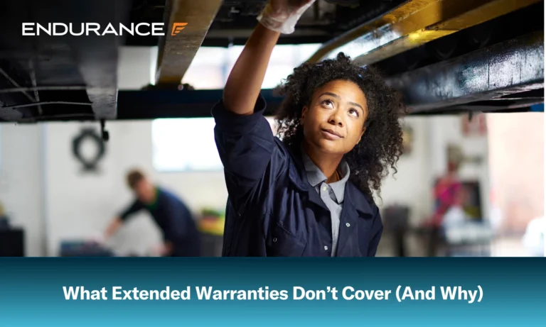 Una joven mecánica adulta parada debajo de un coche en un garaje