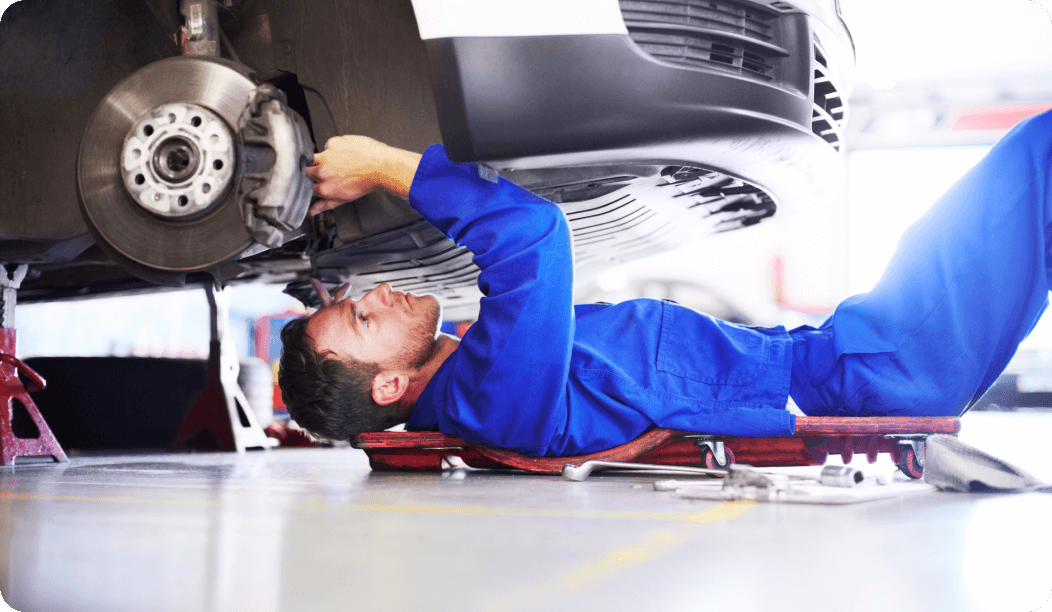 Mecánico trabajando debajo del coche