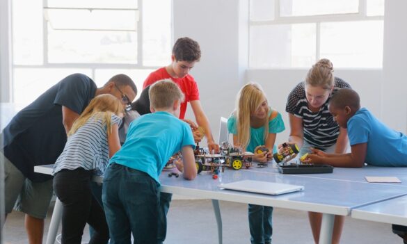 Estudiantes con un profesor trabajando en robots automotrices y programación STEM