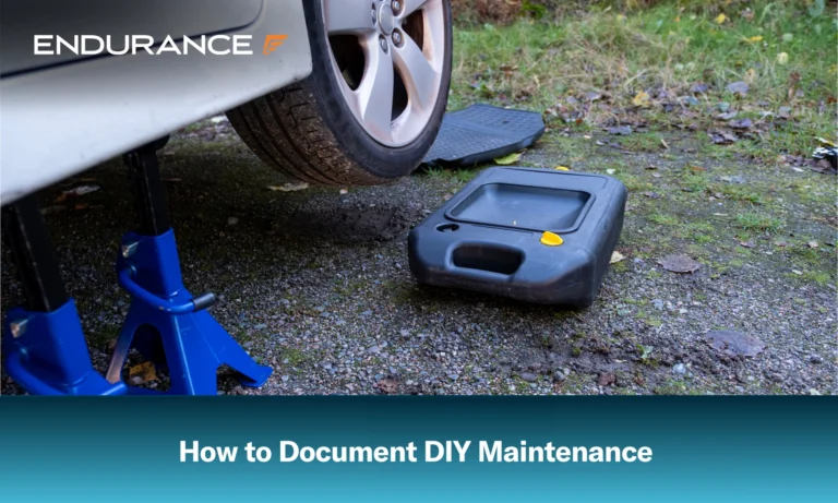 Un automóvil elevado y listo para un cambio de aceite, con un cárter de drenaje de aceite cerca.