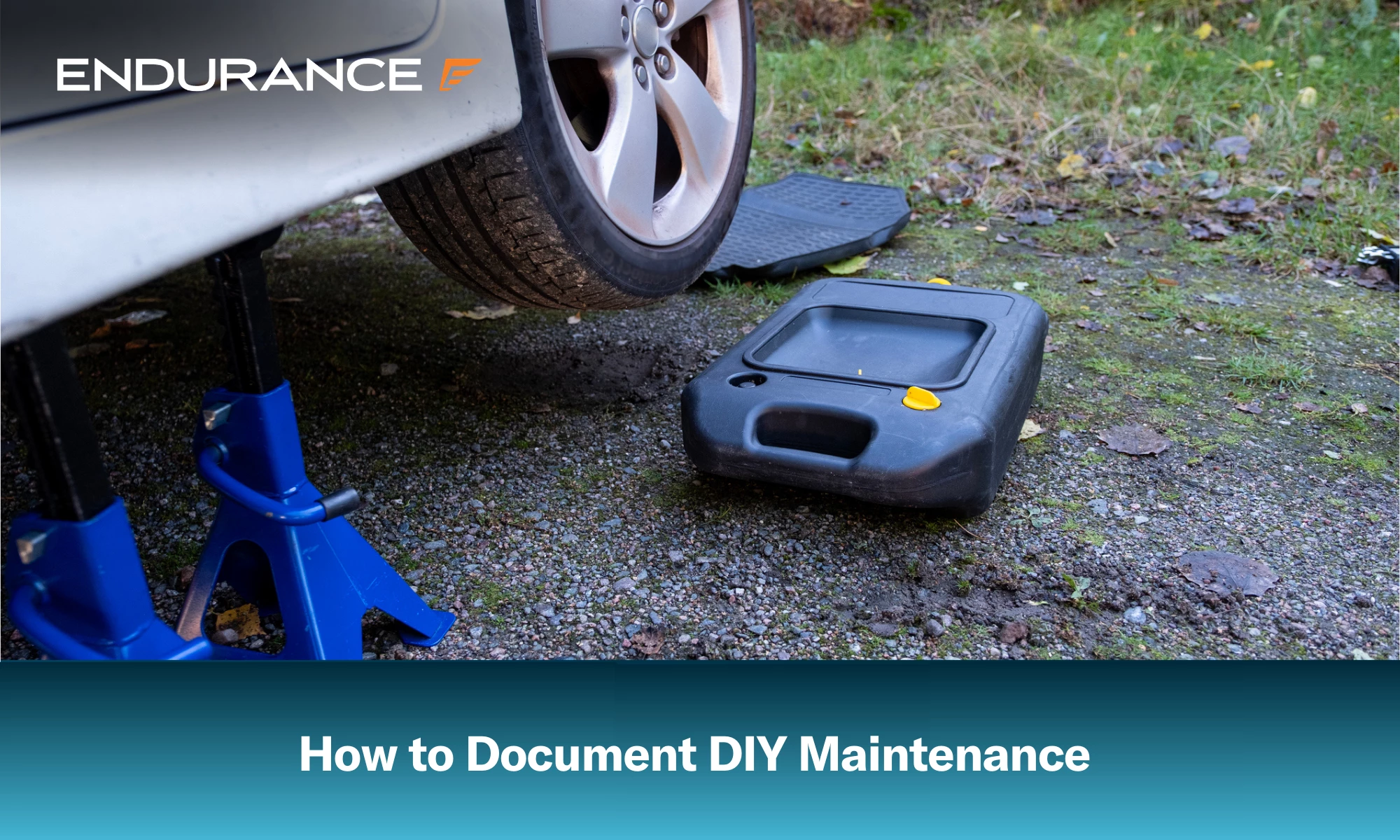 Un automóvil elevado y listo para un cambio de aceite, con un cárter de drenaje de aceite cerca.