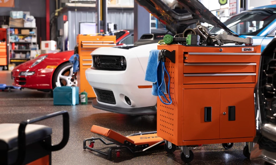 The hood of an car open to see the engine in a garage