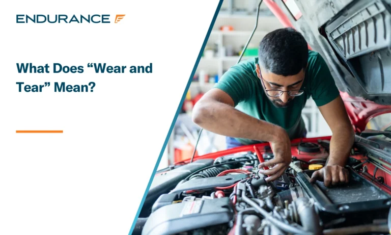 Young man fixing his car at home, what does wear and tear really mean in a vehicle service contract