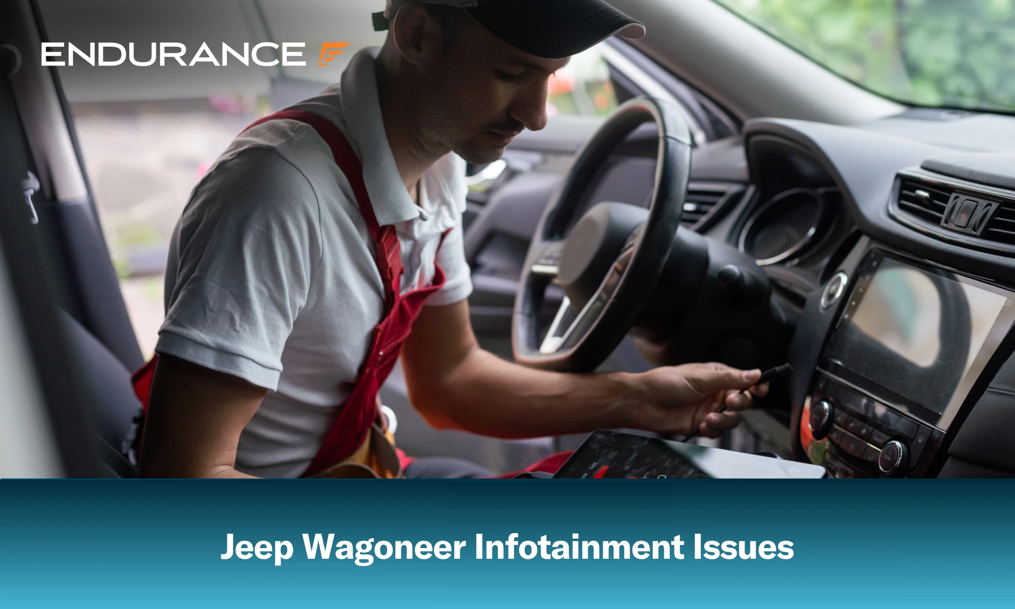 Mecánico sentado en un Wagoneer usando una tableta, problemas con el sistema de infoentretenimiento del Jeep Wagoneer