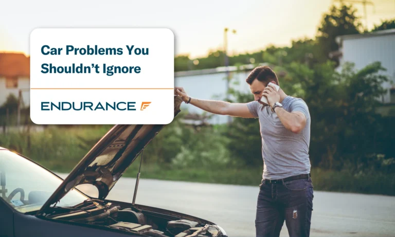 A man calling roadside assistance with his car hood up, learn car problems you shouldn't ignore