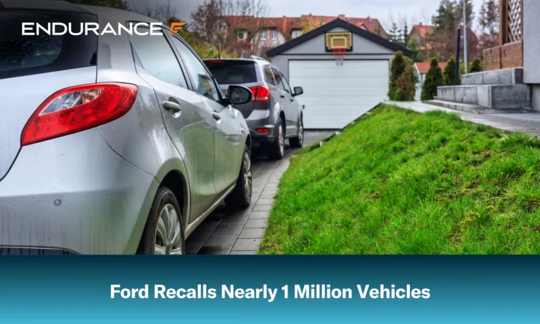 Ford Focus y Explorer estacionados frente a un garaje; Ford retira del mercado 1 millón de vehículos.