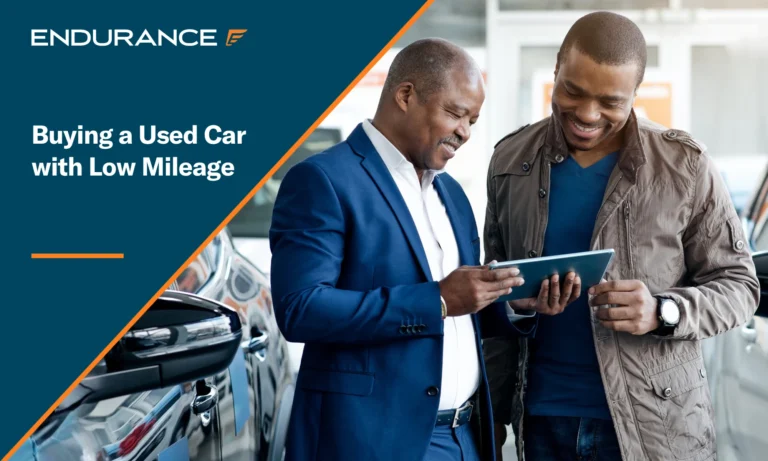 Car salesman selling vehicle to a man, buying a used car with low mileage
