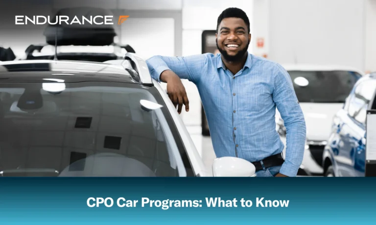 Happy man standing next to a car at a dealership, what to know about CPO car programs